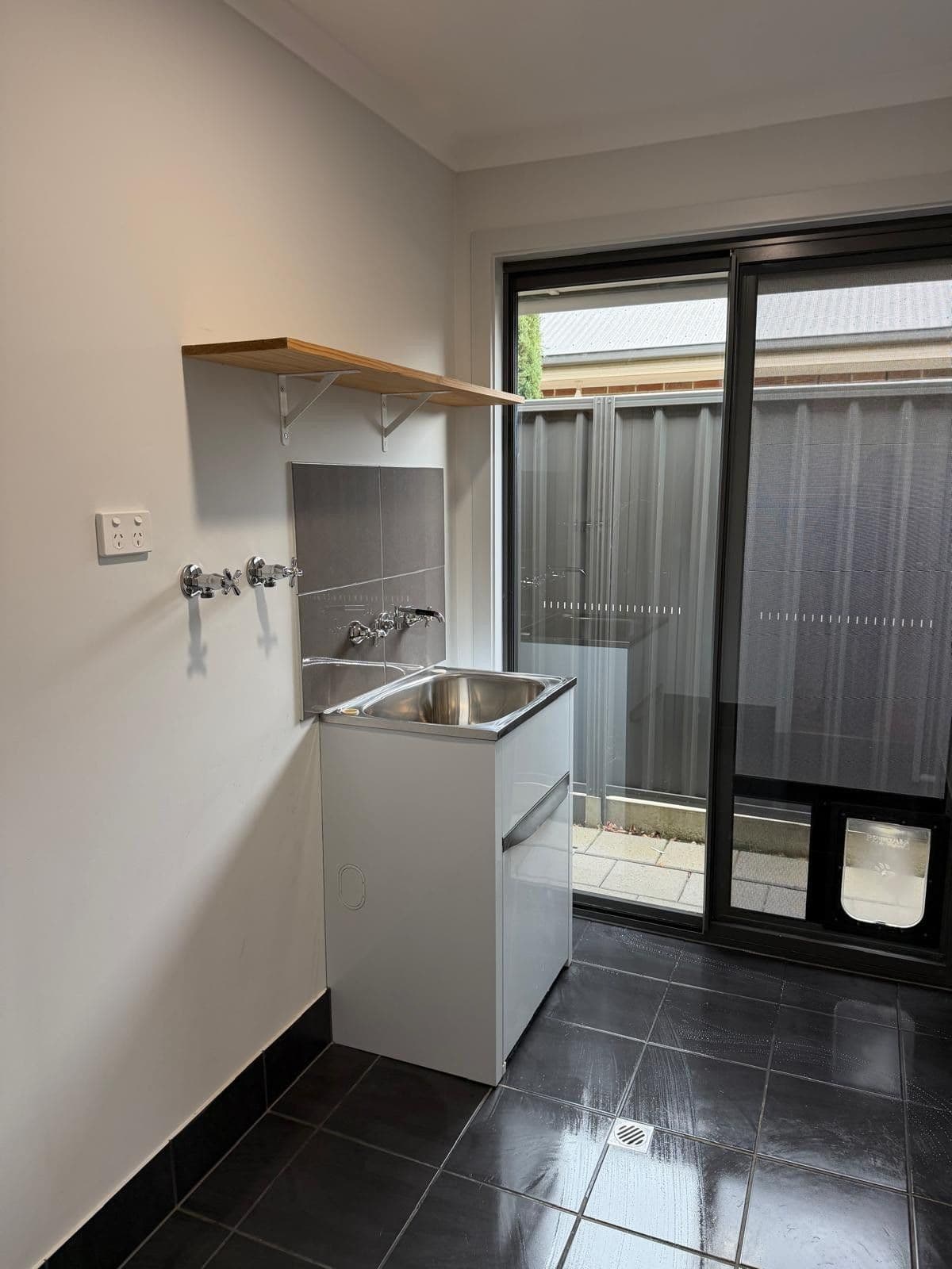 Clean laundry room with sink and sliding door - end of lease clean Adelaide